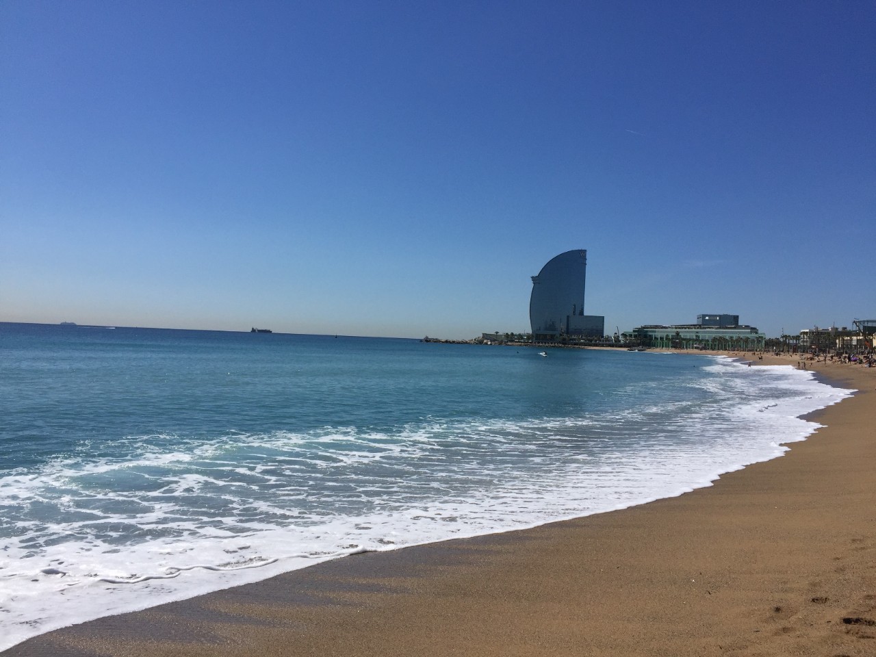 Spiaggia di Barcellona con vista sul grattacielo «Vela», sede di un hotel a cinque stelle.