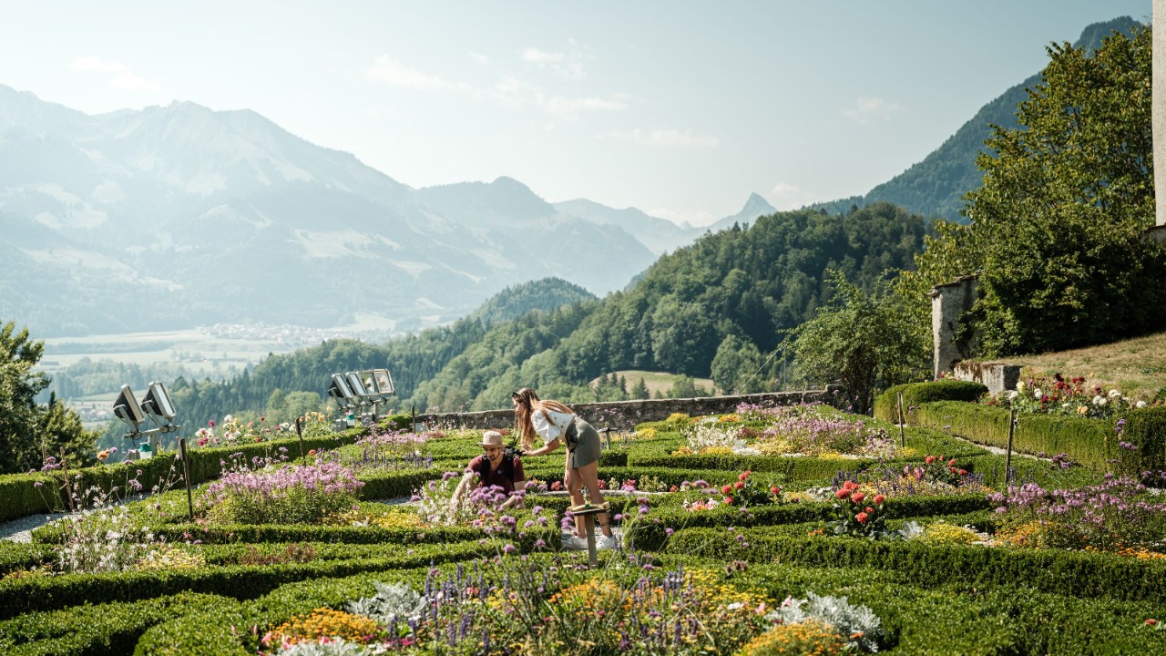 Two people in a castle garden in bloom.